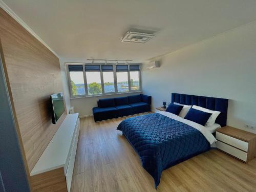 1 dormitorio con 1 cama azul y 1 sofá en 1-к квартира люкс з видом на Дніпро, en Cherkasy