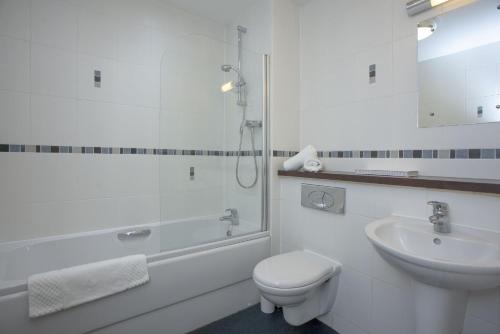 y baño con aseo, lavabo y ducha. en Fistral View, Pentire, en Newquay