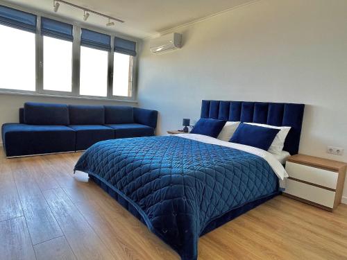 1 dormitorio con 1 cama azul y 1 sofá en 1-к квартира люкс з видом на Дніпро, en Cherkasy