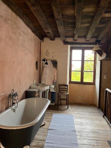 y baño con 2 lavabos y bañera. en Domaine du Banaret - authentic stone house at the heart of Périgord Vert, en Bussière-Badil