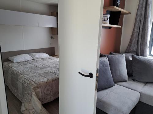 1 dormitorio con 1 cama y 1 sofá en CAMPING LE COTE D'OPALE, en Cucq