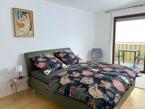1 dormitorio con 1 cama con edredón de flores en Quartier Süd, en Marburg an der Lahn