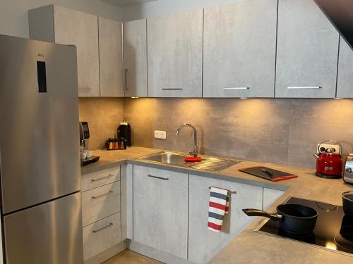eine Küche mit weißen Schränken und einem Edelstahlkühlschrank in der Unterkunft Quartier Süd in Marburg an der Lahn