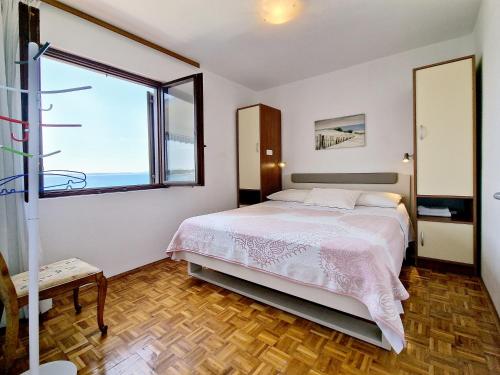 een slaapkamer met een bed en een groot raam bij Villa Katarina in Petrcane