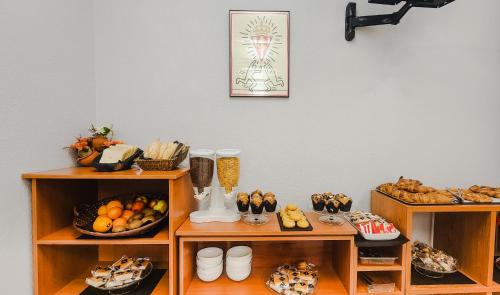 Zimmer mit Regalen mit verschiedenen Arten von Speisen in der Unterkunft Hotel Faranda Express Pathos Gijón in Gijón