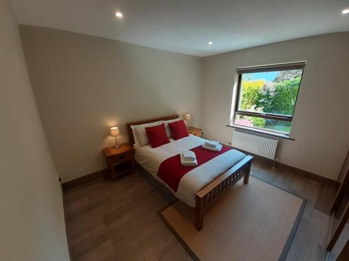 um quarto com uma cama com almofadas vermelhas e uma janela em Highland Haven, Glencoe em Ballachulish