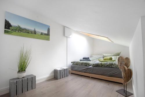 een slaapkamer met een bed in een witte kamer bij Loft mit Seeblick und Innenpool 