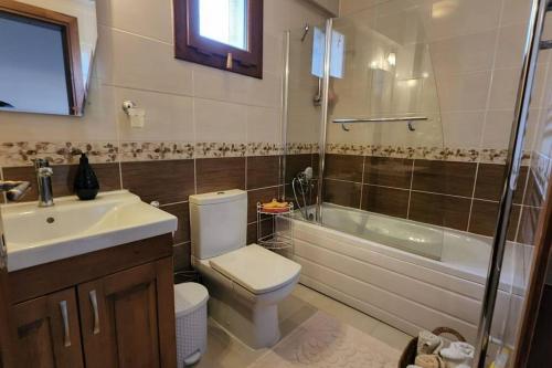 a bathroom with a toilet and a sink and a tub at Fethiye Üzümlüde havuzlu müstakil tatil villası in Fethiye