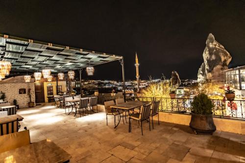 a rooftop patio with tables and chairs at night at Goreme House in Goreme