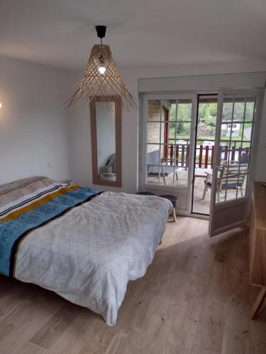 Schlafzimmer mit einem Bett und einem Kronleuchter in der Unterkunft Gîtes BEL'M in La Bresse