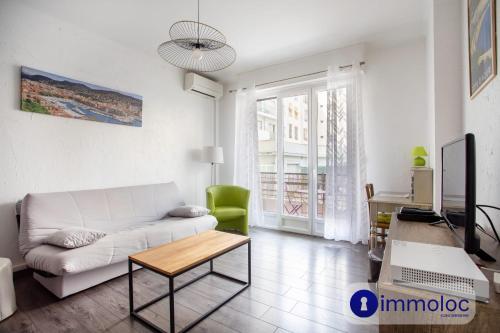 un salon avec un canapé blanc et une table dans l'établissement Apartment near the center Borriglione district, à Nice