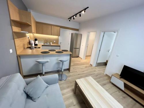 een woonkamer met een witte bank en een keuken bij Sofia Opera Apartment in Sofia