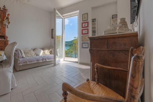 um quarto com uma cadeira, uma cama e uma janela em Letizia lake house panoramic view em Colle di Tora