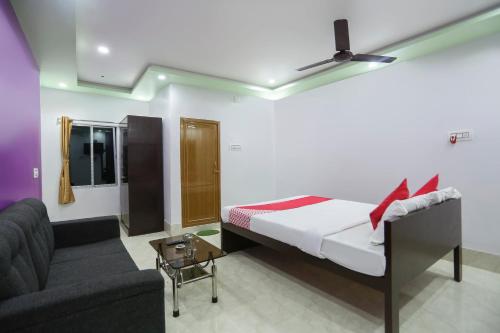 BaharampurにあるOYO Flagship 67063 Roy Villa Resortのベッドとソファ付きのホテルルーム