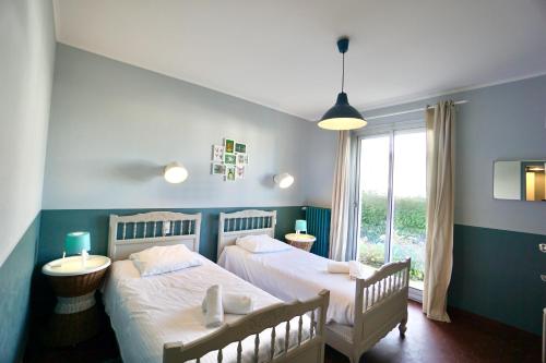 une chambre avec deux lits et une fenêtre dans l'établissement Sea Cottage, à Trégunc