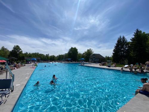 un grupo de personas en una gran piscina en 1 Minute to Pool & Beach, Spacious Getaway, AC, Hot tub, Game room, en Pocono Country Place