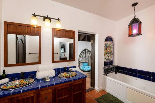 ein Badezimmer mit einem Waschbecken, einer Badewanne und einem Spiegel in der Unterkunft Casa Colibri + Casita - Villa w/ocean views in Vieques