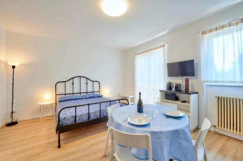 uma sala de estar com uma mesa e uma cama em Appartamento Pinus Varenna em Varenna