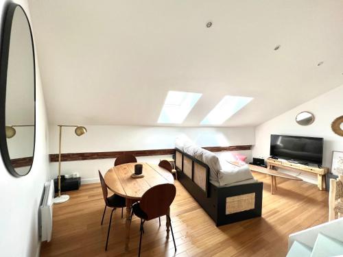 Appartement au centre de Toulouse في تولوز: غرفة معيشة مع طاولة وأريكة