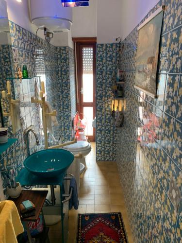 baño con 2 lavabos y una pared de azulejos azules en Little House, en Nettuno