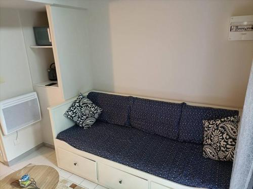 Cette chambre dispose d'un canapé et d'oreillers. dans l'établissement Agréable et paisible studio, à Franqueville-Saint-Pierre