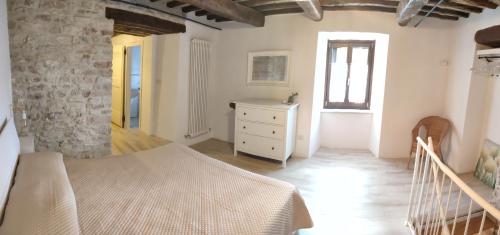 a bedroom with a bed and a dresser and a window at APPARTAMENTI VACANZA SAN SILVESTRO in Piobbico