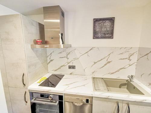 a kitchen with marble counter tops and a sink at Domaine de la Rue de la Tour in Valsonne