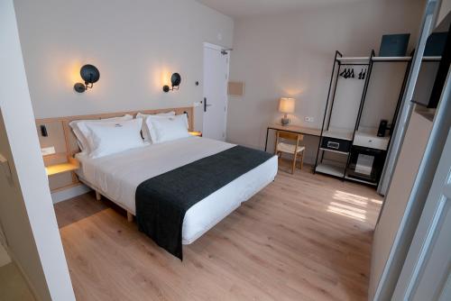 - une chambre avec un grand lit blanc et du parquet dans l'établissement Casa del Médico Hotel Boutique, à Alcázar de San Juan