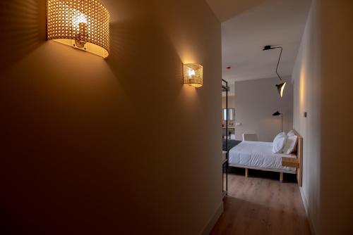 a bedroom with a bed and two lights on the wall at Casa del Médico Hotel Boutique in Alcázar de San Juan