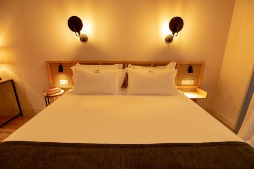 a bedroom with a large bed with white pillows at Casa del Médico Hotel Boutique in Alcázar de San Juan