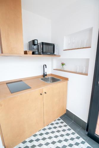 a kitchen with a sink and a microwave at Casa del Médico Hotel Boutique in Alcázar de San Juan