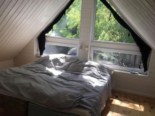 - un lit non aménagé dans une chambre avec 2 fenêtres dans l'établissement Egen Ö med unik upplevelse, 
