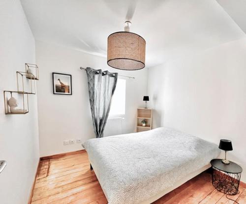 Maison avec terrasse cosy, 2 chambres, wifi, parking في Ruelle-sur-Touvre: غرفة نوم بيضاء بها سرير ونافذة