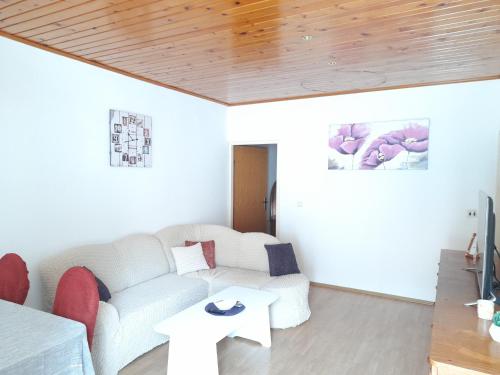 a living room with a white couch and a table at Apartments Sponga in Polače