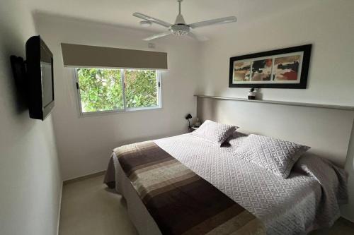 Un dormitorio con una cama y un ventilador de techo. en Depto Parque Urquiza Parana ER, en Paraná