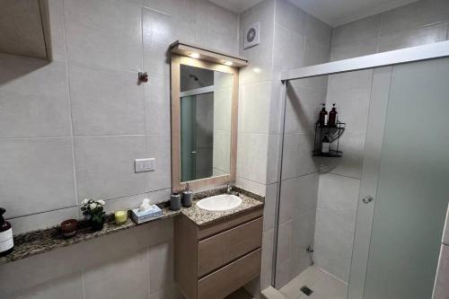 a white bathroom with a sink and a mirror at Depto Parque Urquiza Parana ER in Paraná