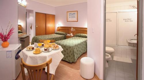 ブエノスアイレスにあるグラン ホテル ドゥ ラ ペのテーブルとバスルーム付きのホテルルームです。