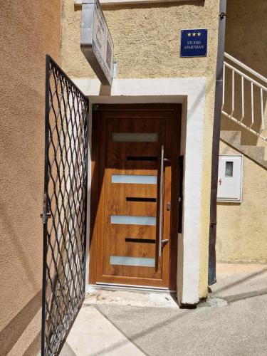 eine Holztür in einem Gebäude mit einem Tor in der Unterkunft ZAD Senj Apartman in Senj