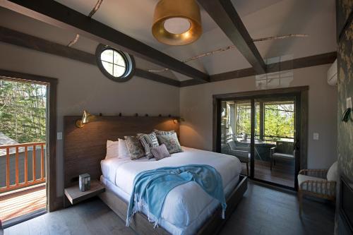 a bedroom with a large bed and a balcony at Hidden Pond Resort in Kennebunkport