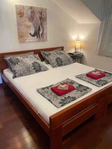 a bed with two red pillows on top of it at Apartments Daniela in Korčula