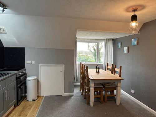 a kitchen with a wooden table and a table and chairs at Faldouet 3 bed flat in Rock in Saint Minver