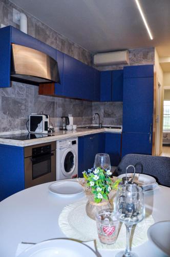 een keuken met blauwe kasten en een tafel met wijnglazen bij Appartamento Urbino in Urbino