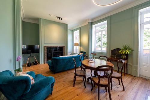 a living room with blue furniture and a table at The Grove Houses in Guimarães