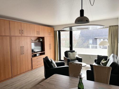 uma sala de estar com uma mesa e cadeiras e uma televisão em Germania-34 em Sankt Peter-Ording