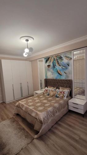 a bedroom with a large bed with a painting on the wall at Sea View House in Sumqayıt