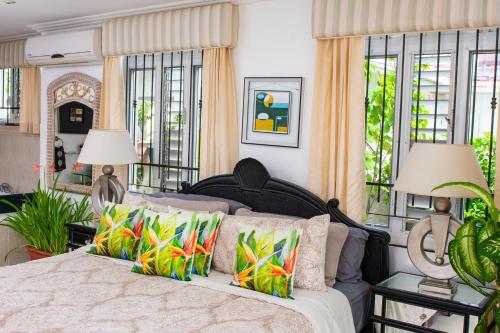a bedroom with a large bed with colorful pillows at ZenBreak Bliss Tranquility in Bridgetown