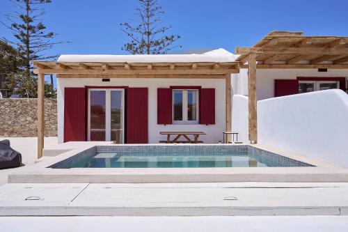 a villa with a swimming pool in front of a house at Casa Philippi Suites in Mýkonos City