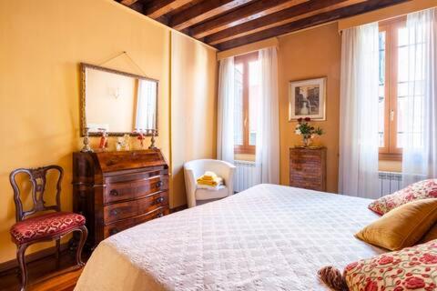 - une chambre avec un lit, une commode et un miroir dans l'établissement appartamento nel cuore di venezia, à Venise