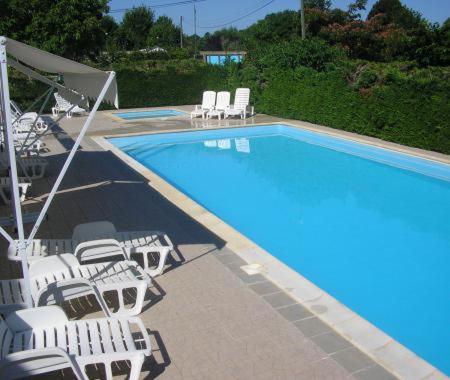 a swimming pool with white chairs and a bunch ofitures at Mobile home au camping les Tilleuls du Caminel in Sarlat-la-Canéda