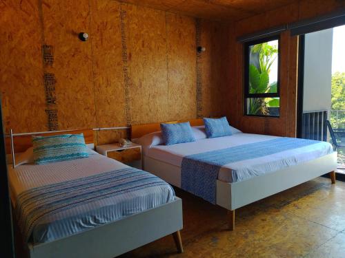 1 dormitorio con 2 camas y ventana en Hotel Momotus en Tuxtla Gutiérrez